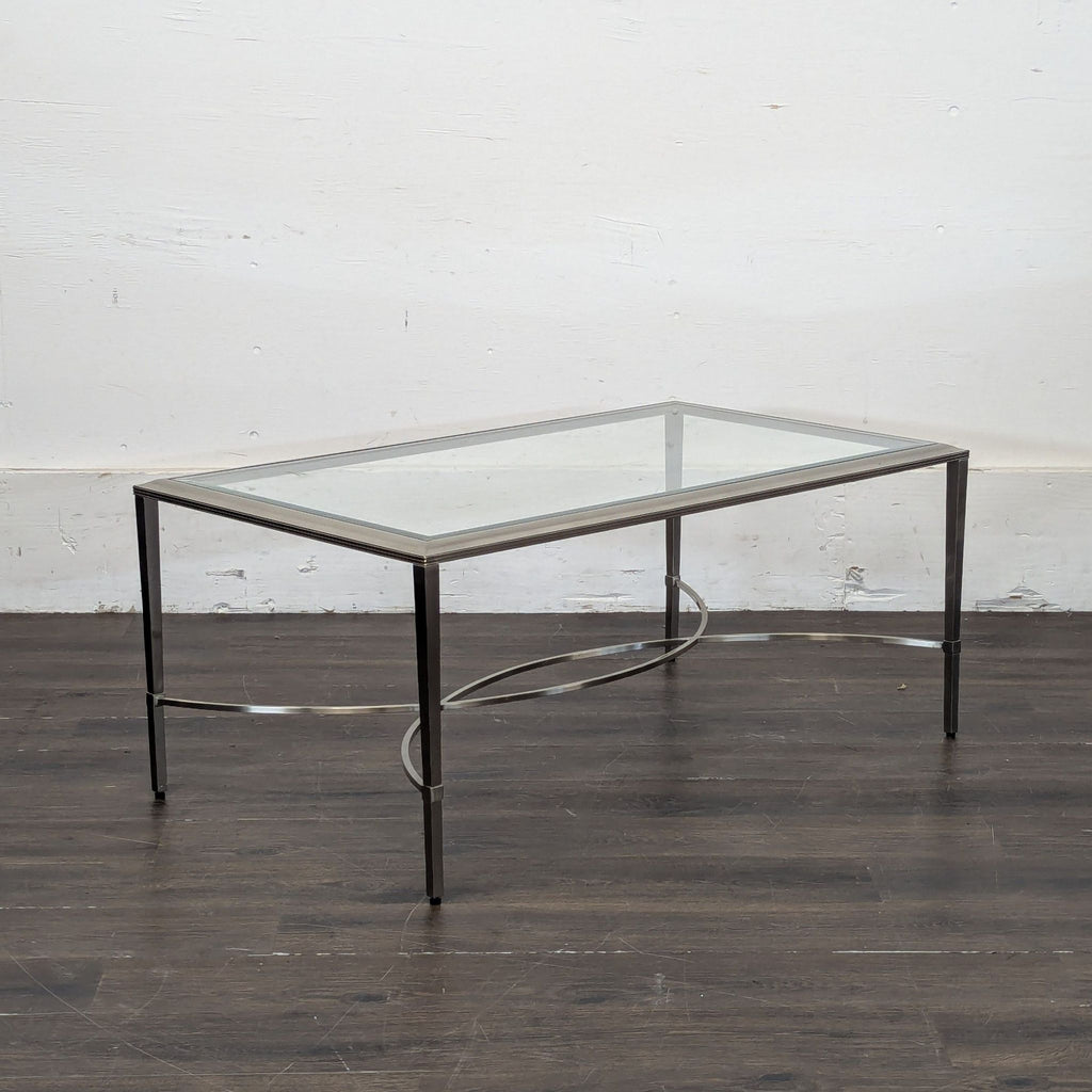 2. Side view of a modern Ethan Allen coffee table featuring a glass surface and sleek metal legs.