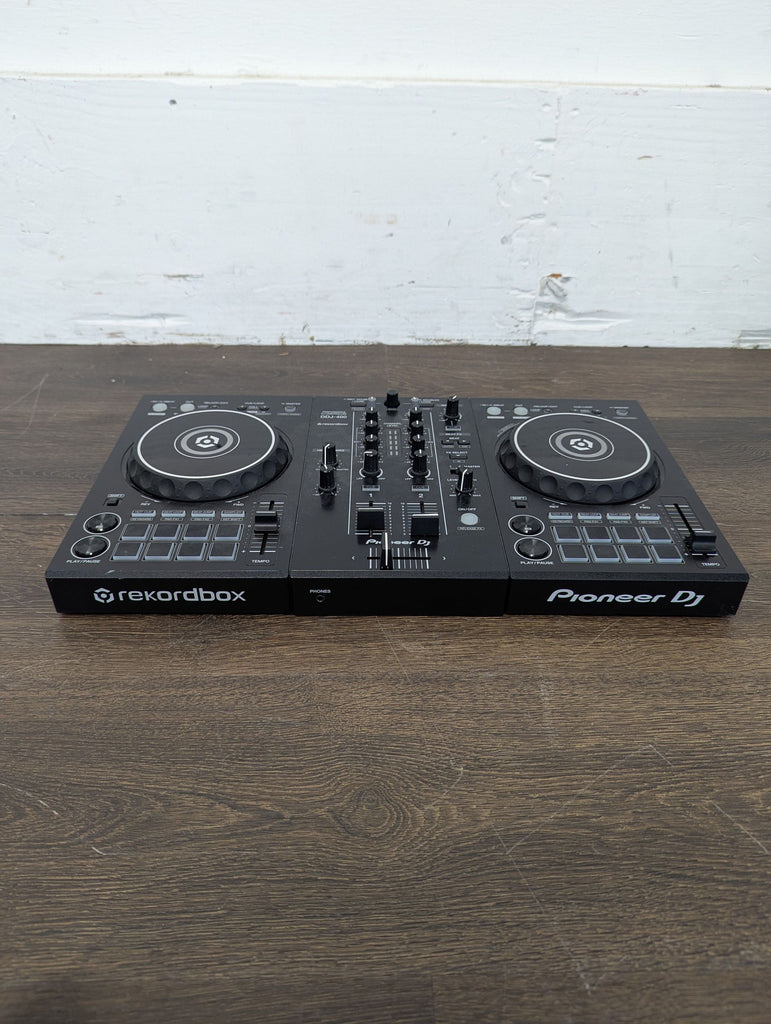 Top-down view of a well-maintained Pioneer DJ DDJ-400, showcasing controls and jog wheels for mixing.  