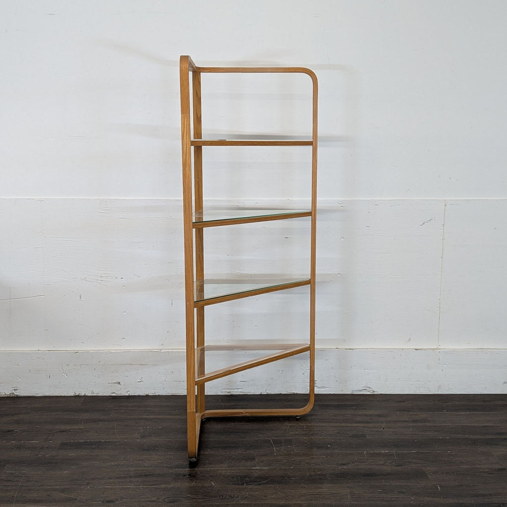 2. Tall, dark-finished bookshelf filled with assorted books and plants, standing against a white wall.