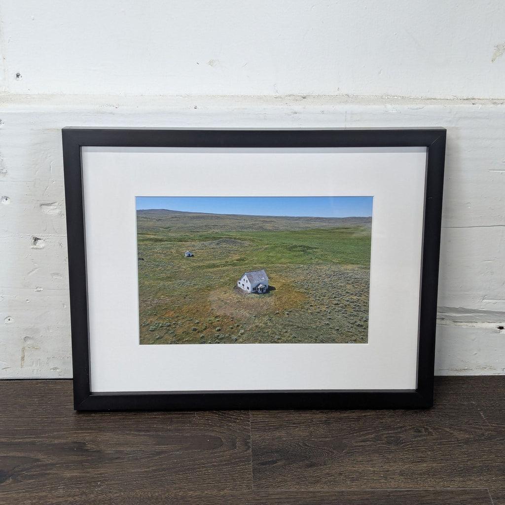 2. Art print of a rural open field with a weathered, deserted house at the center, displayed in a black frame.