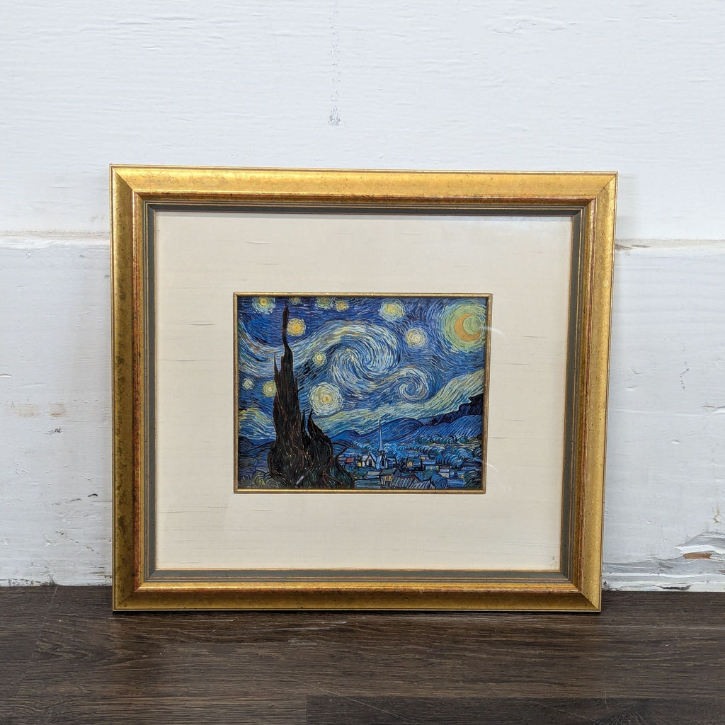 2. "Starry Night" framed art print, gold frame and white mat, placed against a white wall and dark floor.