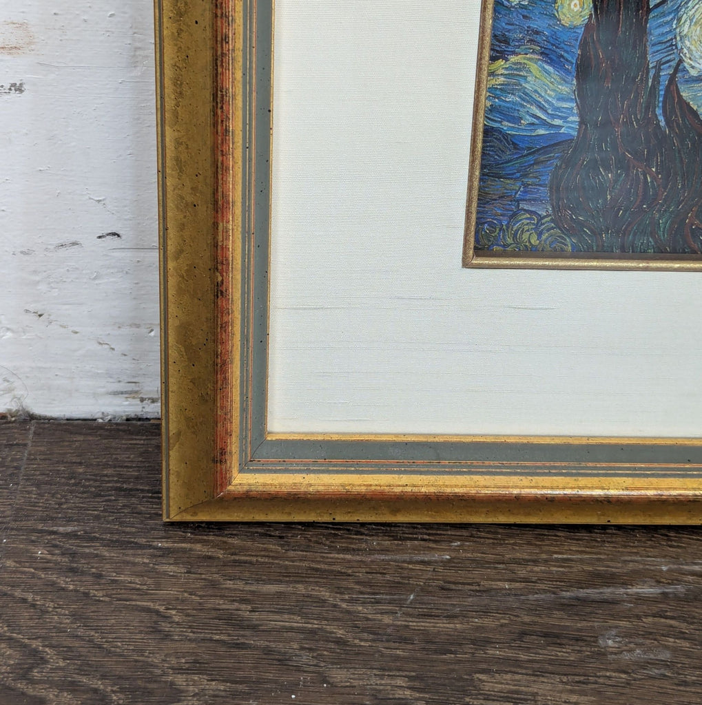 3. Close-up of lower left corner of a gold-framed "Starry Night" print, showing frame and mat texture.