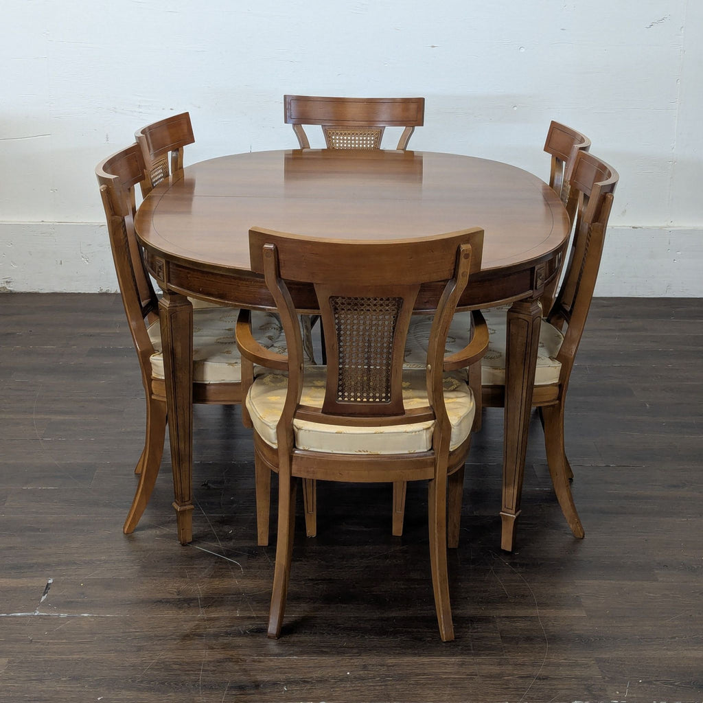 3. Round view of a Thomasville wood dining table with six matching cushioned chairs arranged around it.