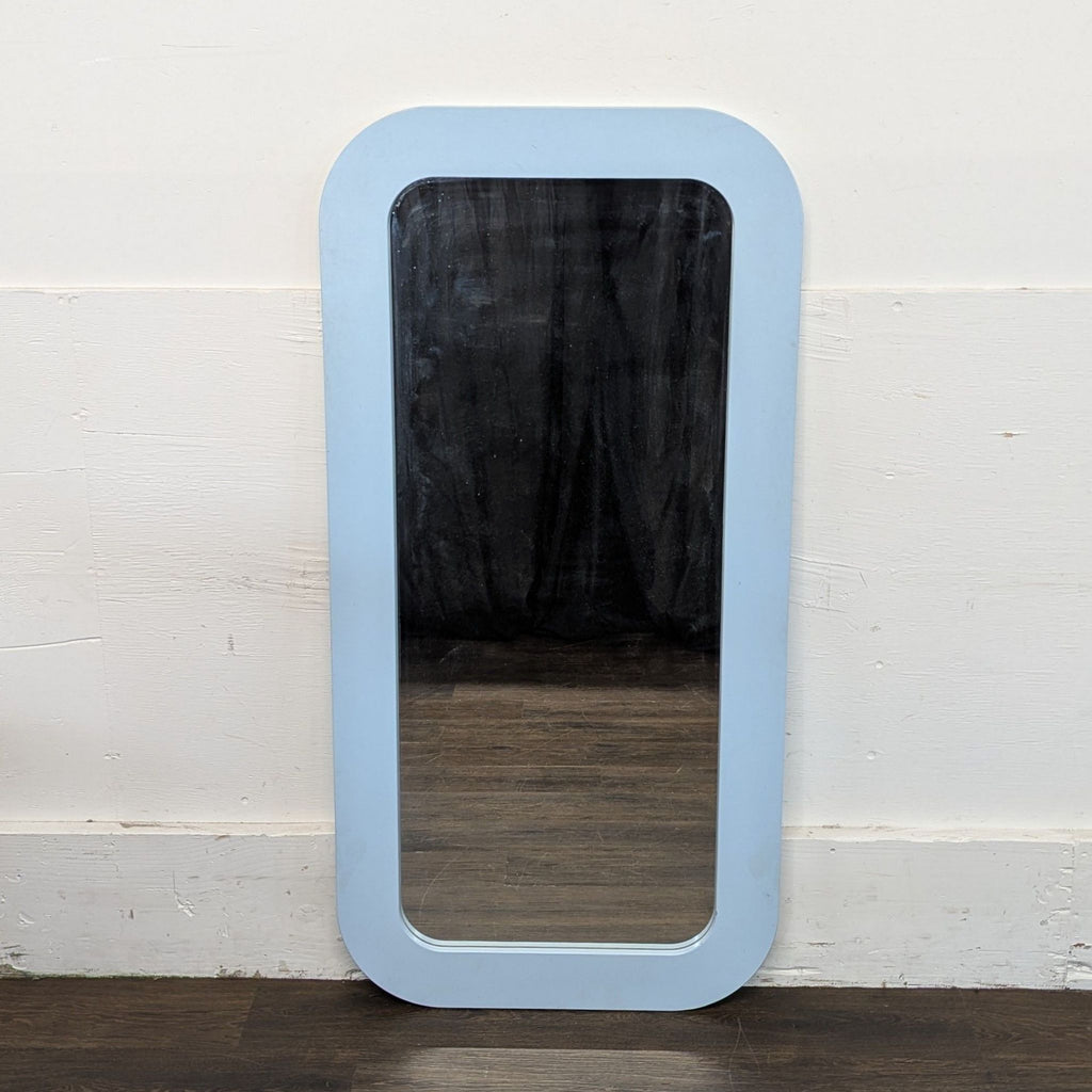 1. Oval Ikea mirror with a slim metal frame, photographed hanging on a pastel-colored wall.