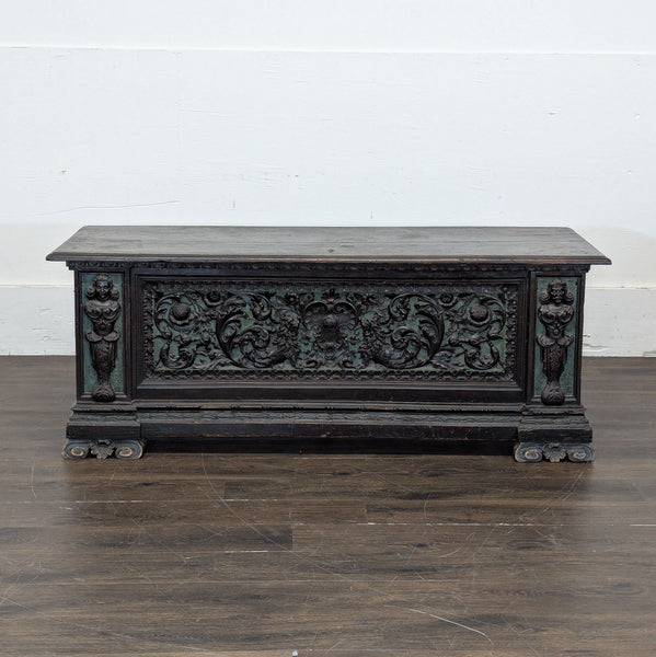 1. Ornate wooden trunk with intricate carved floral designs and decorative figures on the front panel.  