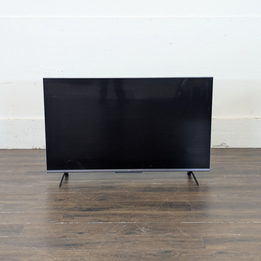 2. TCL R646 television with matching stand, emphasizing a minimalist and stylish home entertainment setup.  