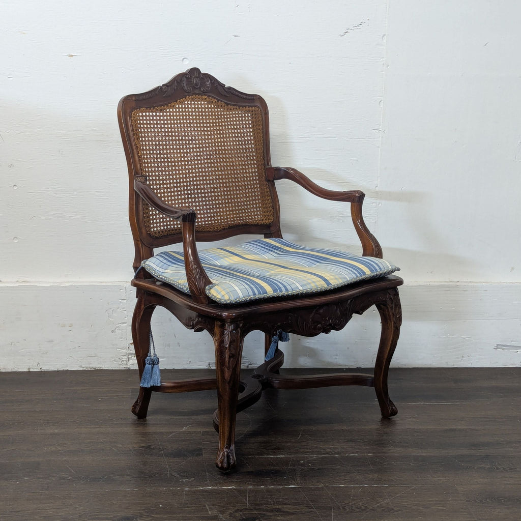 3. Angled view of a classic wooden dining chair with carved details, caned back, and plush striped cushion.