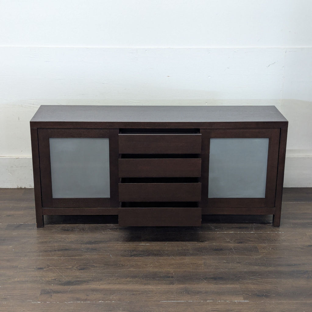 Sleek wooden sideboard by Crate and Barrel; sliding doors open to expose shelving for versatile storage.