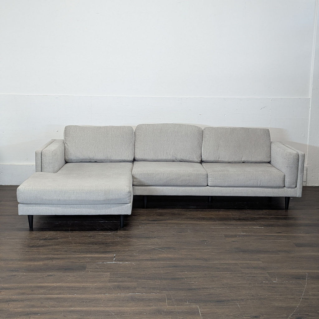 2. Contemporary Sectional by Living Spaces featuring a chaise lounge, clean lines, and soft cushions in neutral tones.