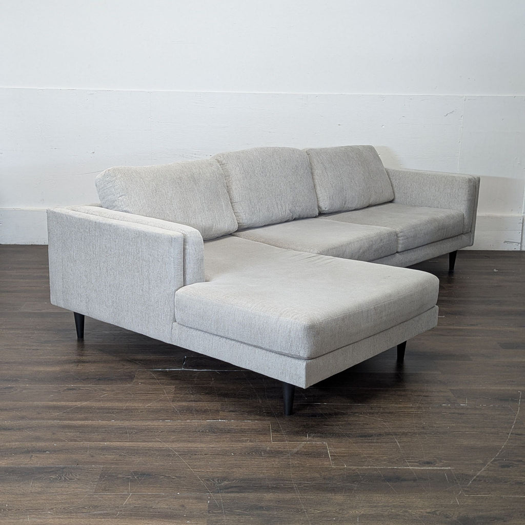 3. Living Spaces sectional sofa in elegant grey fabric, arranged for comfort and style in a modern home setting.