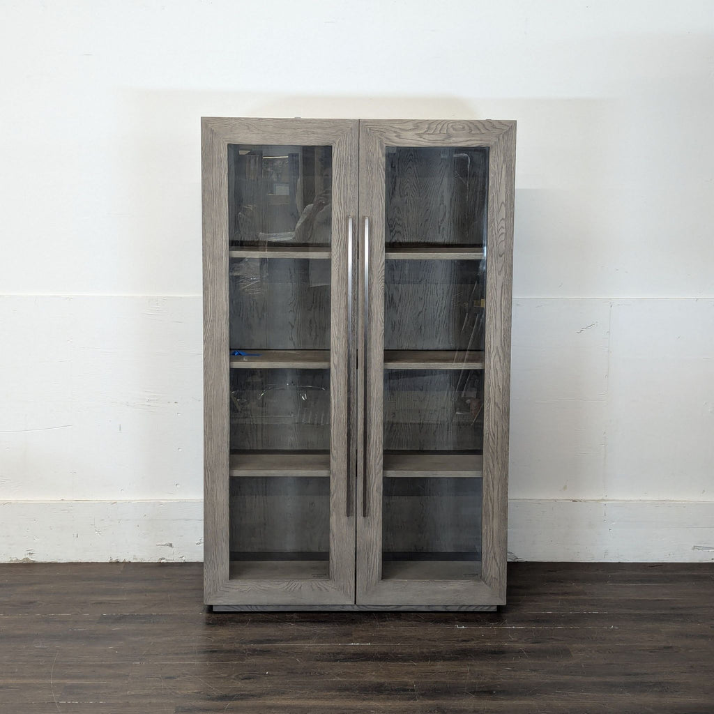 1. Elegant Restoration Hardware cabinet with glass doors and sleek metal handles, ideal for modern interiors.