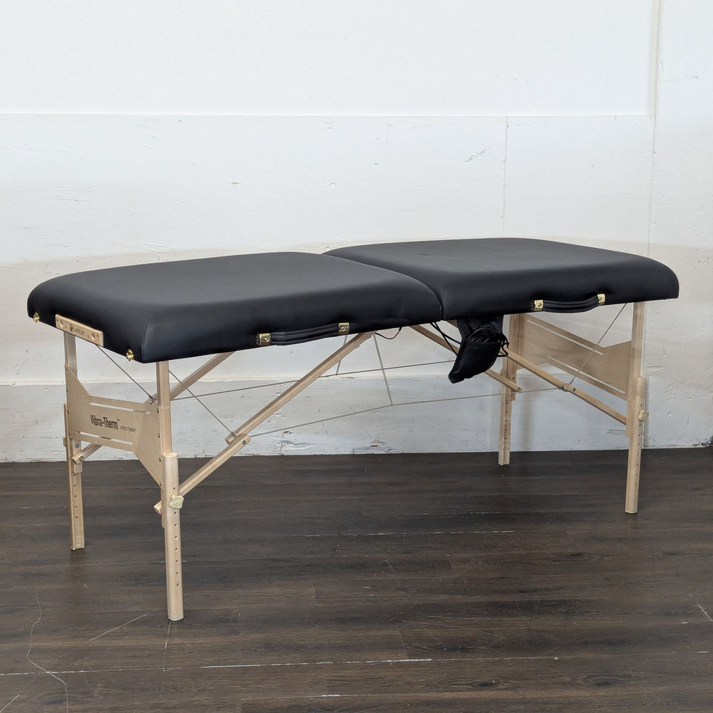 Earthlite massage table with cushioned surface and wooden legs, designed for comfort and stability.  