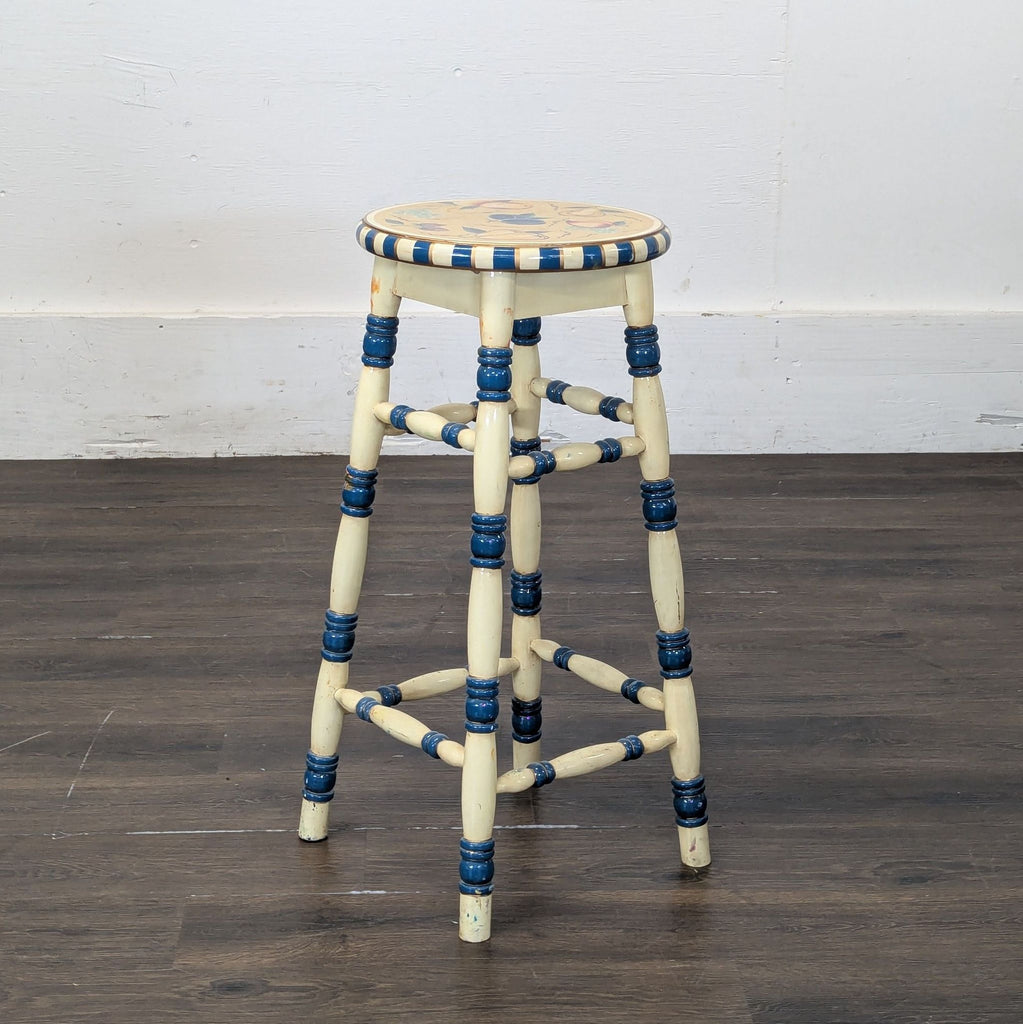 3. Tall painted wooden stool featuring turned legs, blue details, and a colorful hand-painted seat design.