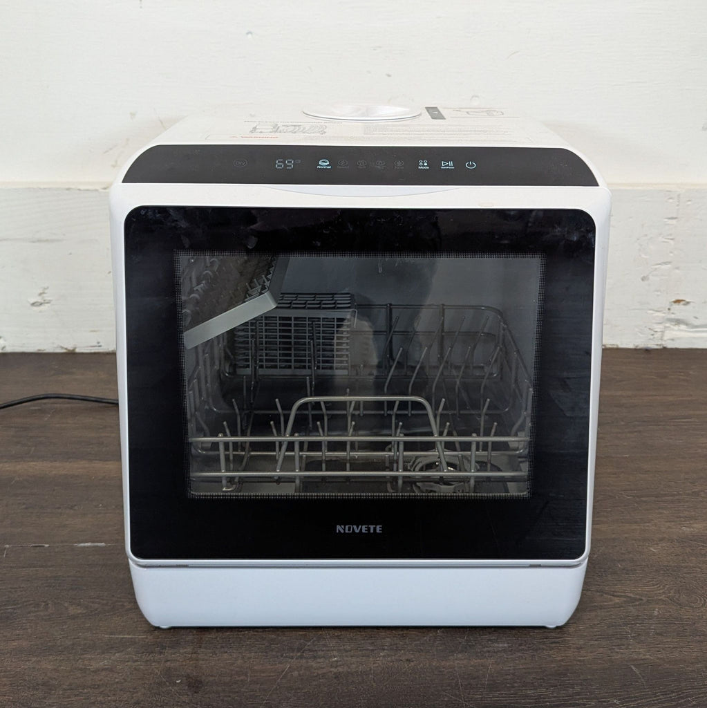 3. Mini dishwasher in a home setting with glassware inside and a blue-lit interior, door open on a shelf.