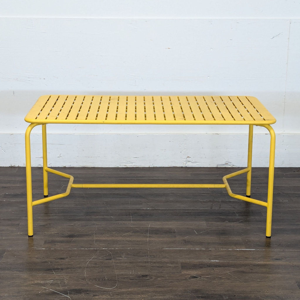 Contemporary outdoor dining table in coral, featuring a slatted design and rectangular shape from Petite Friture.