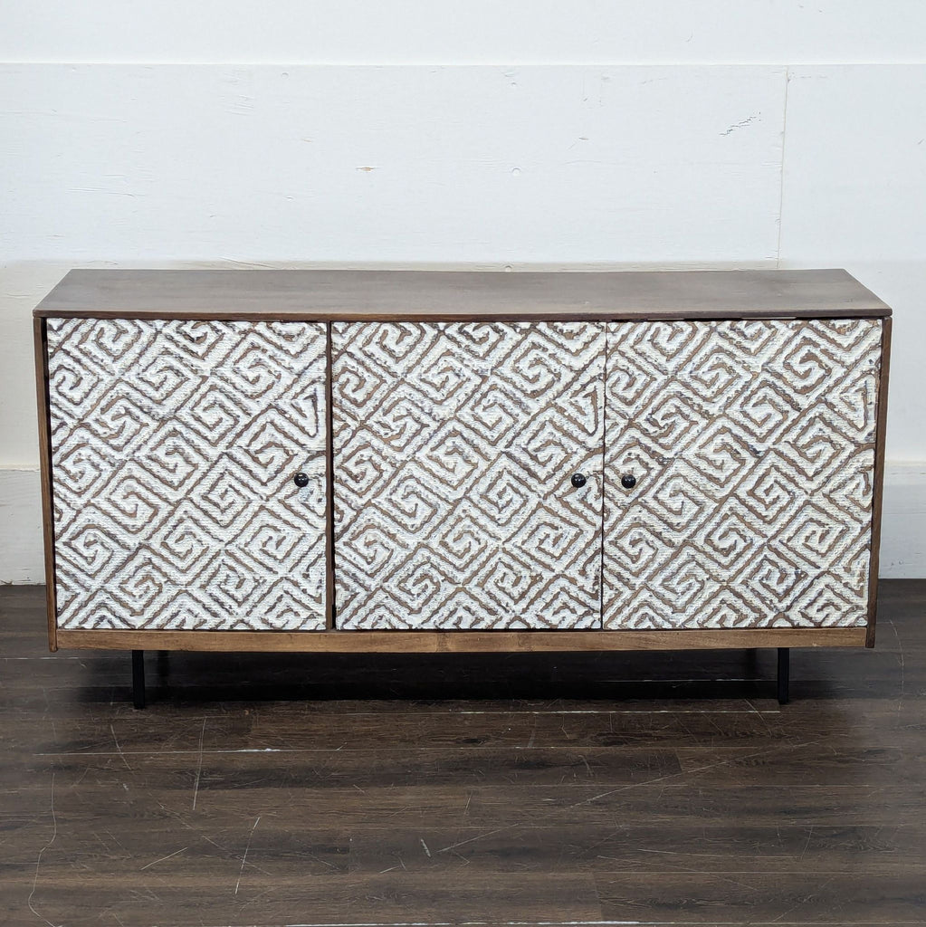 2. Modern Ashley Furniture entertainment center with white geometric pattern doors, shown closed on a wooden floor.