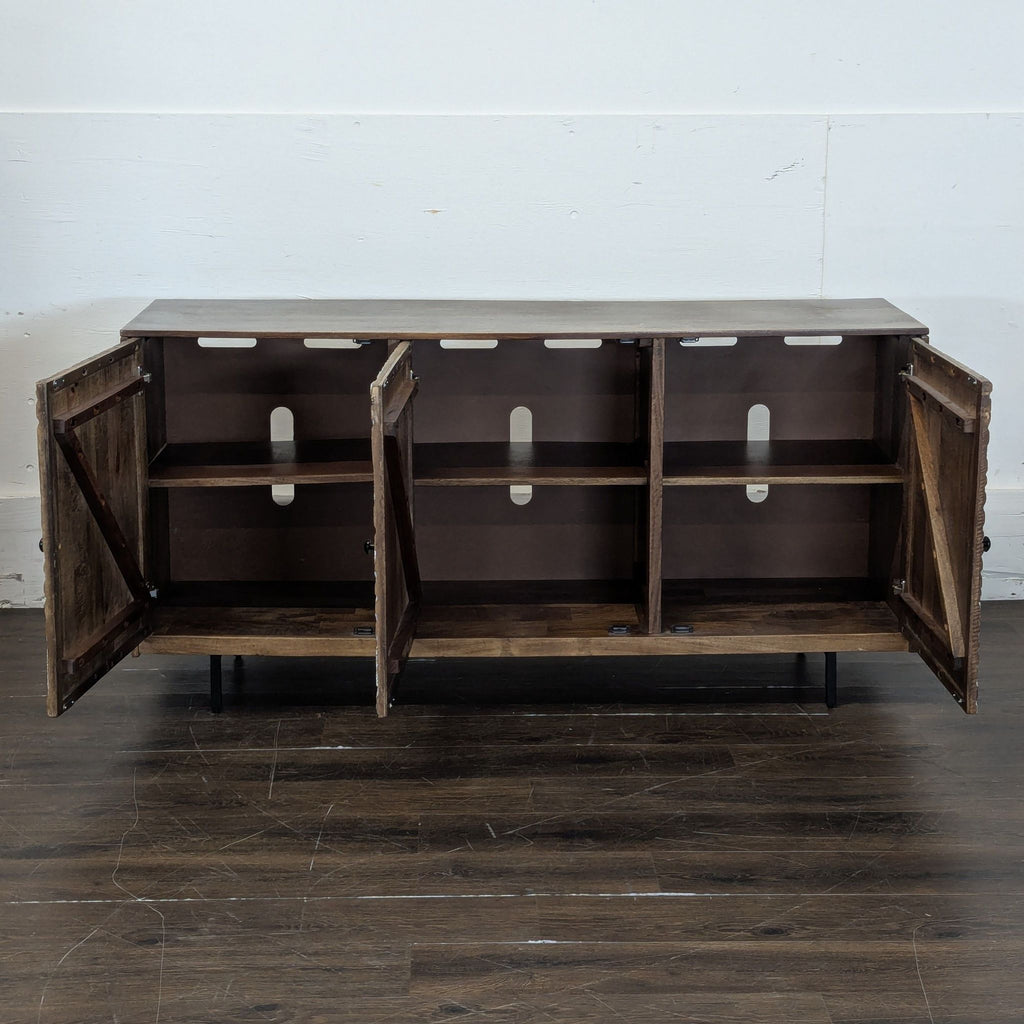 3. Ashley Furniture entertainment center with doors open, displaying spacious shelving and cord management holes.