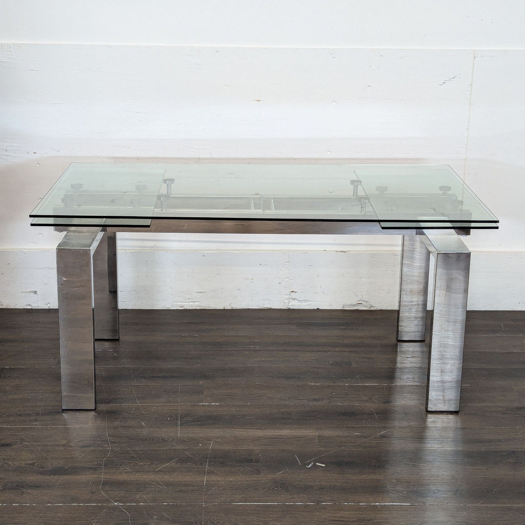 3. Sleek coffee table featuring a double glass top and polished metal legs, placed on a dark wood floor.
