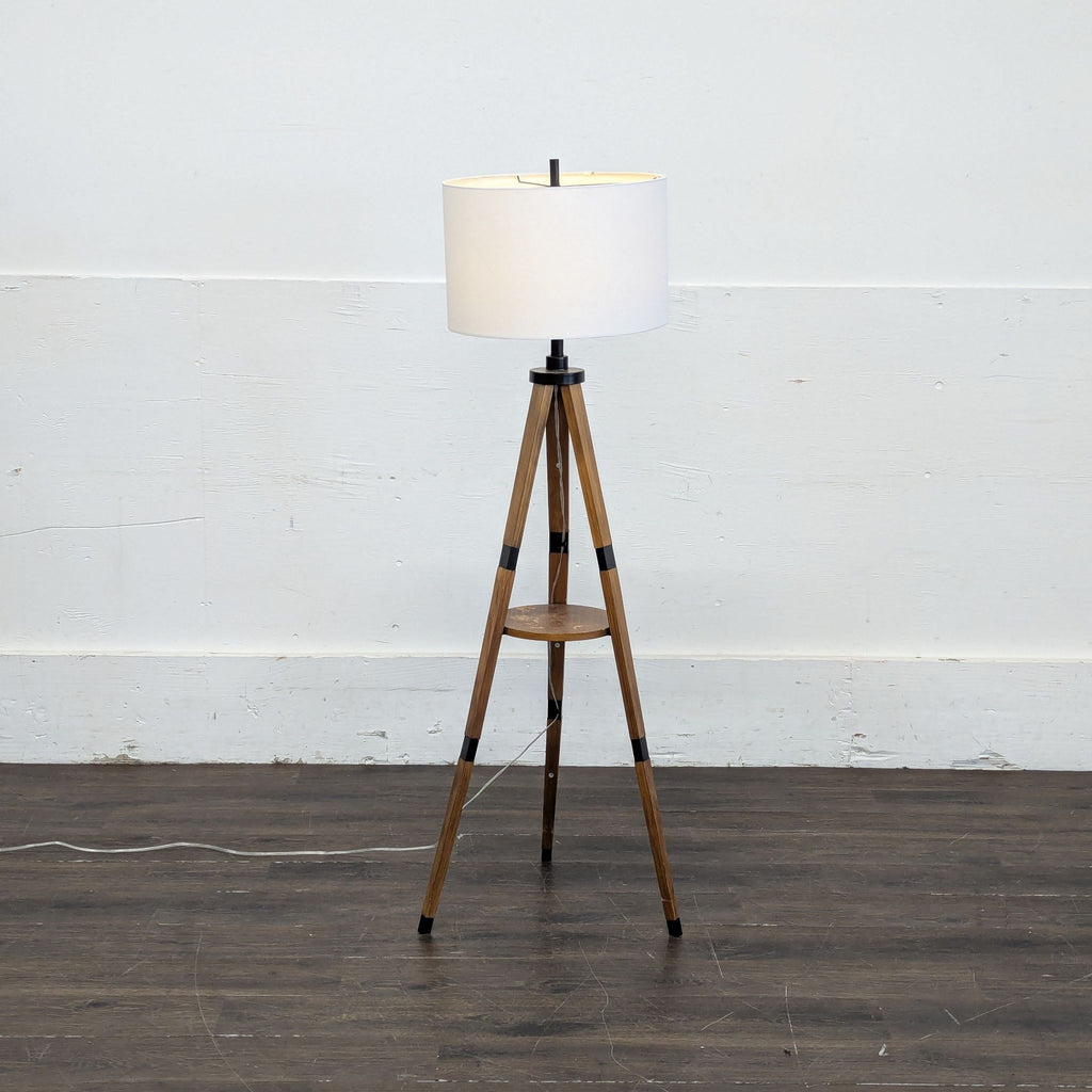1. Target tripod floor lamp with wooden legs, black accents, and a white drum shade, set on a wooden floor.
