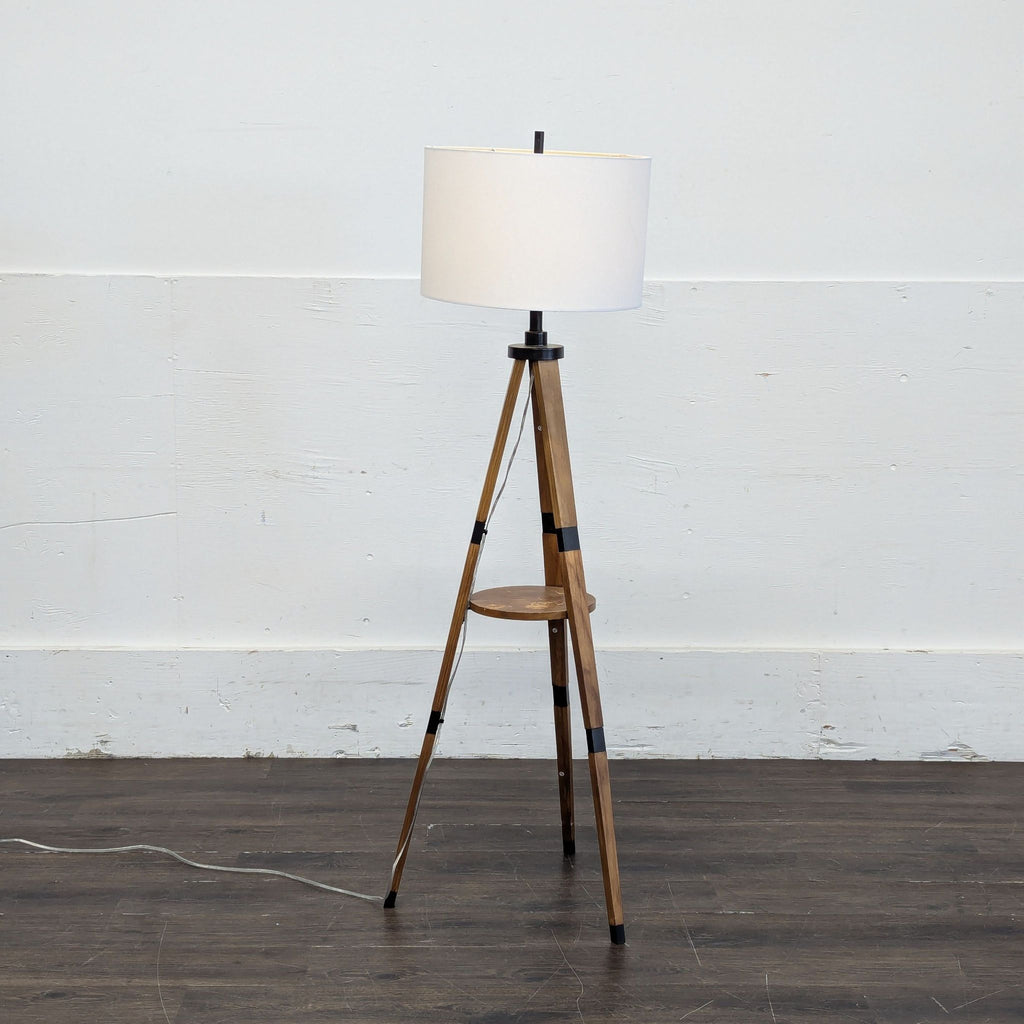 2. Modern Target floor lamp features a white shade, wood tripod base, and central shelf, in a minimalist room.