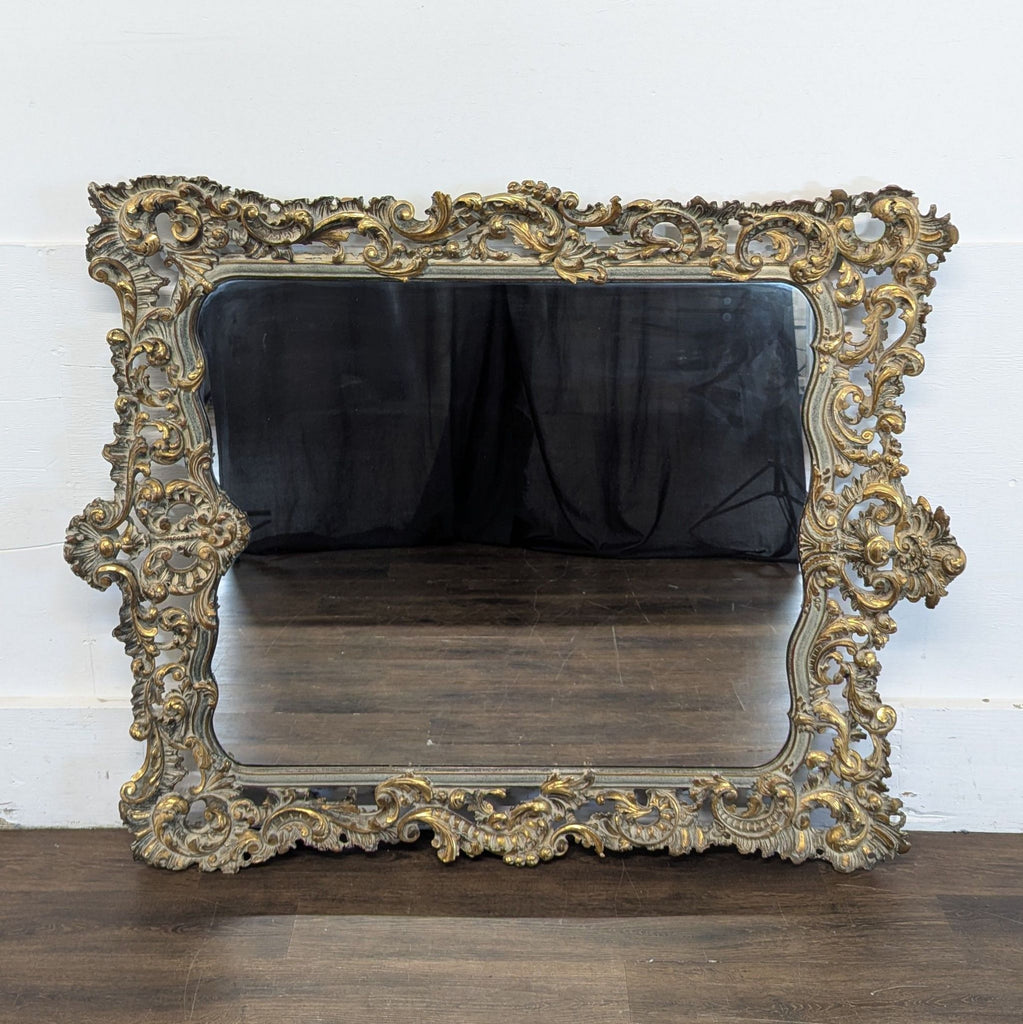 2. Antique-style mirror with elaborate baroque frame in gold and grey tones, resting on a wooden floor.