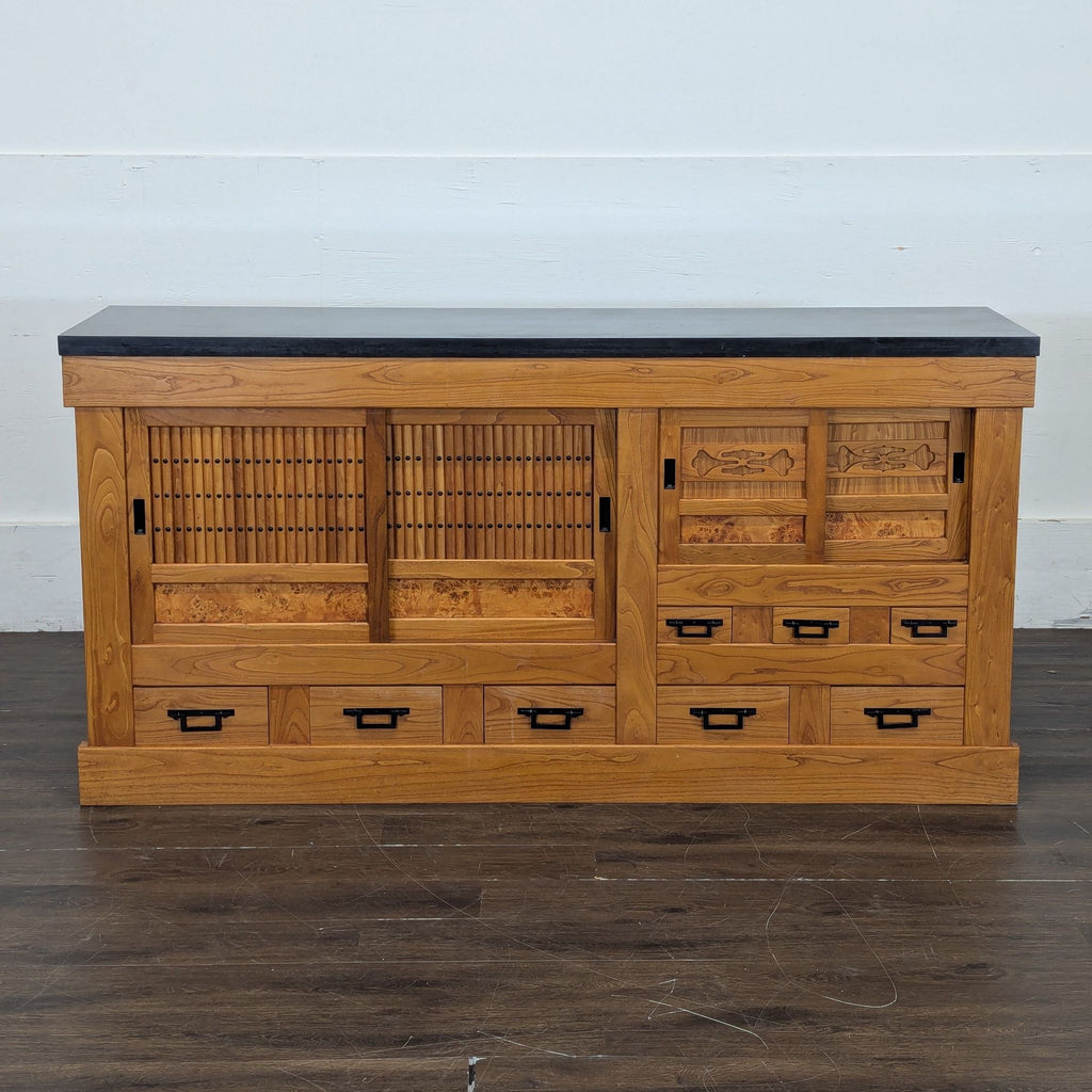 3. Traditional-style wooden entertainment center with intricate sliding doors and several storage drawers.