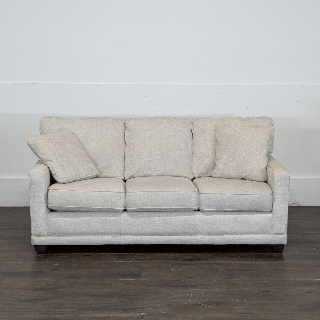 2. Neutral upholstered La-Z-Boy 3-seat sofa, shown front-facing on a dark wood floor with plush cushions.