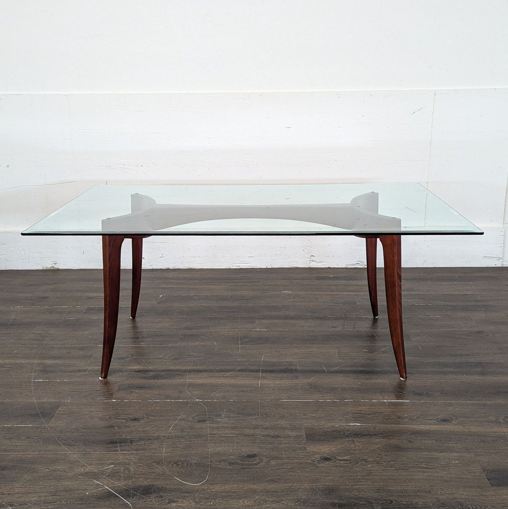 Modern dining table with glass top and six Z Gallerie chairs, including two armchairs.