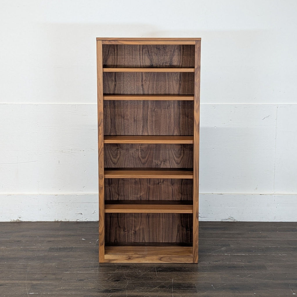 2. Sleek wooden Room & Board bookshelf offering ample storage for books and accessories.