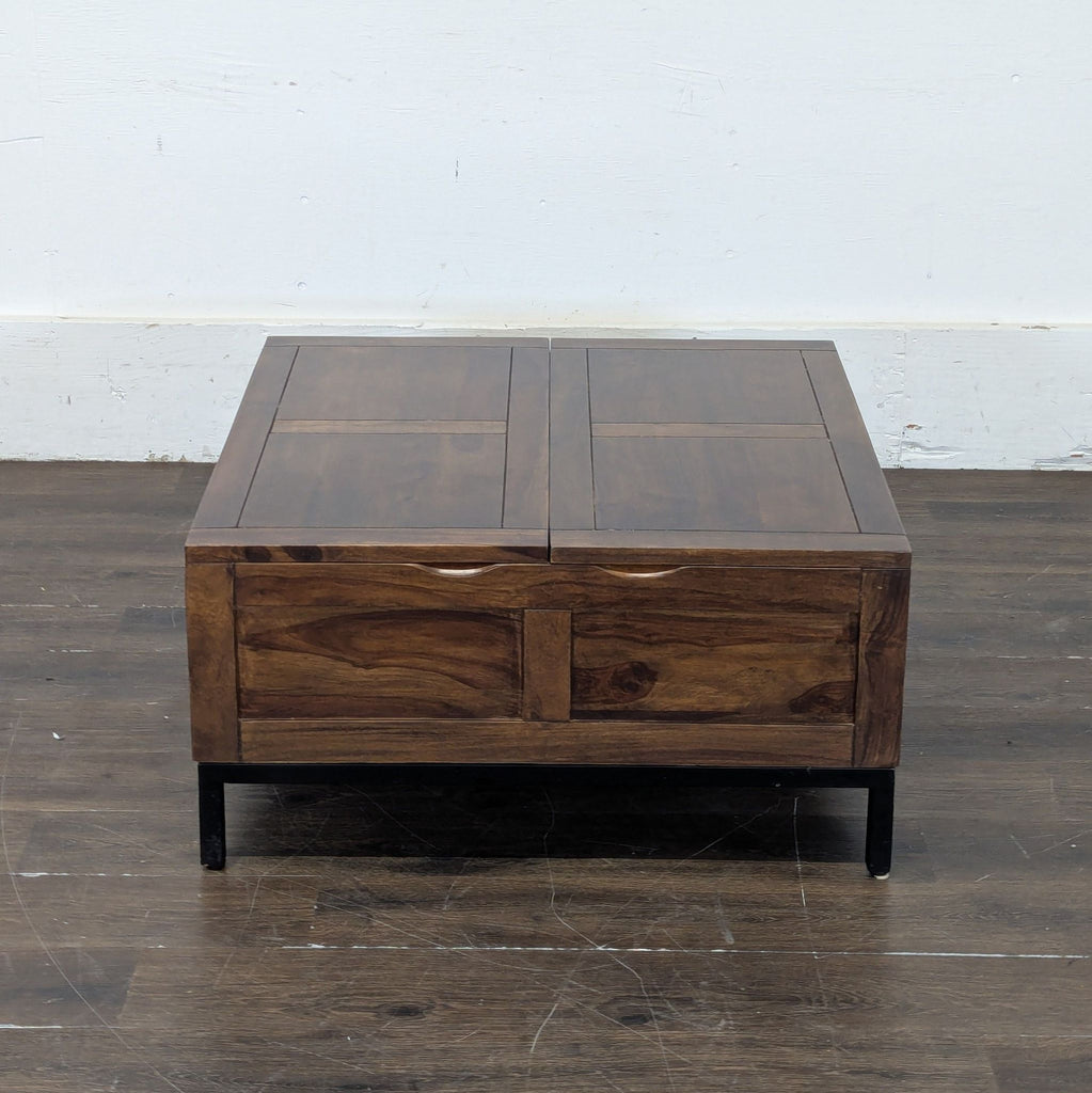 2. Crate & Barrel coffee table in a rich wood tone with panel detailing and black legs, viewed from the front.