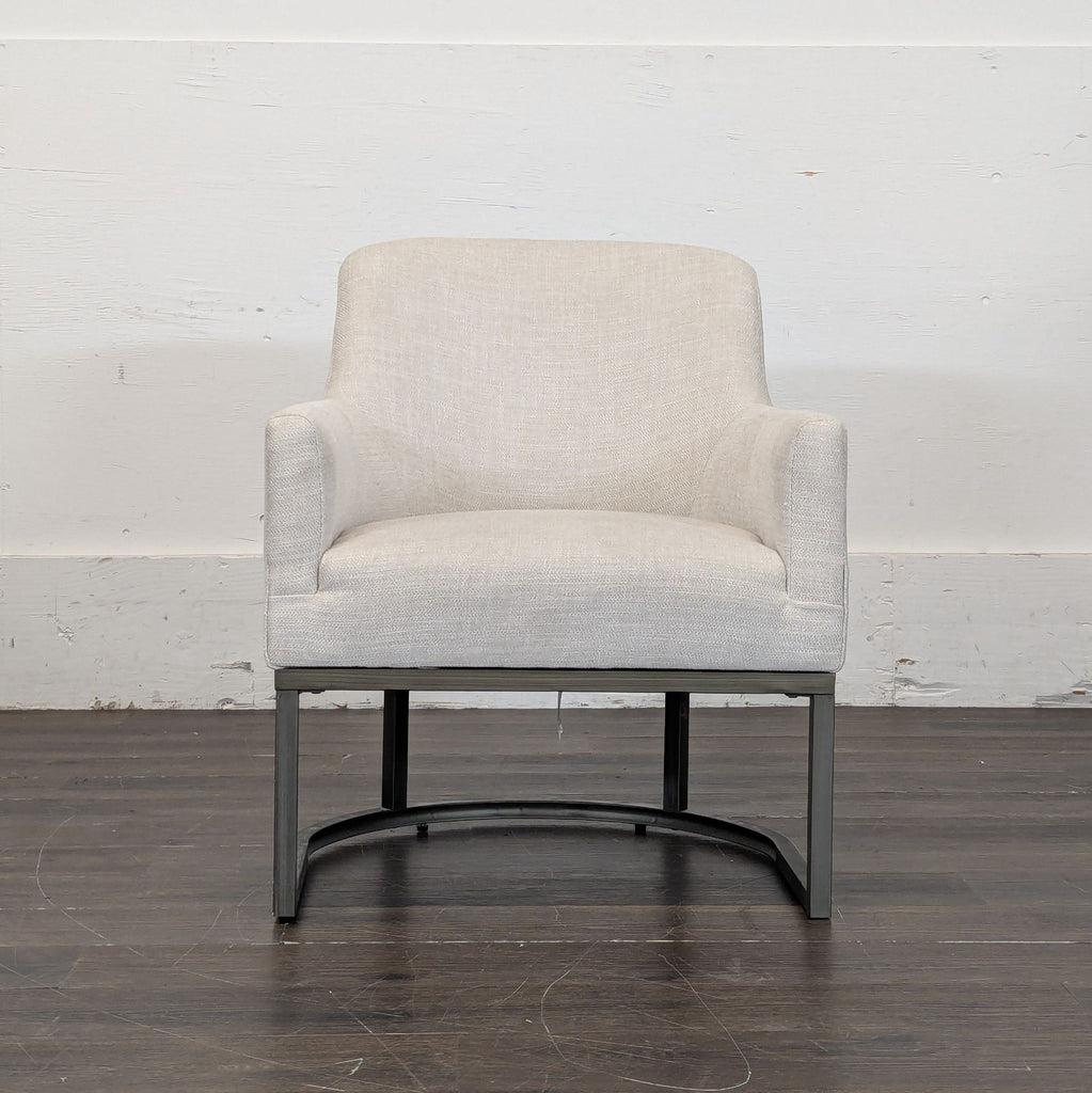2. Modern E&E Co. lounge chair with light upholstery and metal legs, displayed against a plain wall.