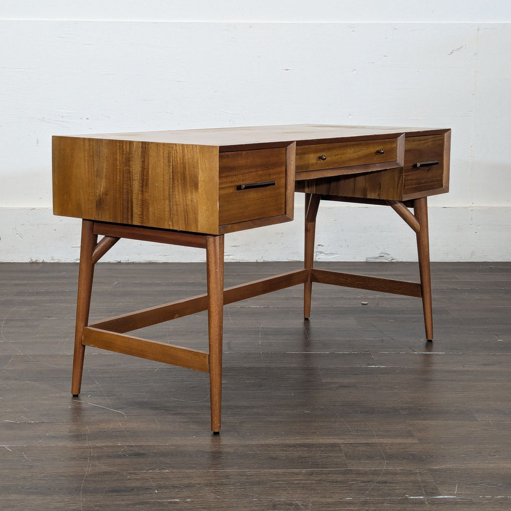 2. Angled view of a vintage wooden desk with two side drawers and one middle drawer, featuring sleek handles.
