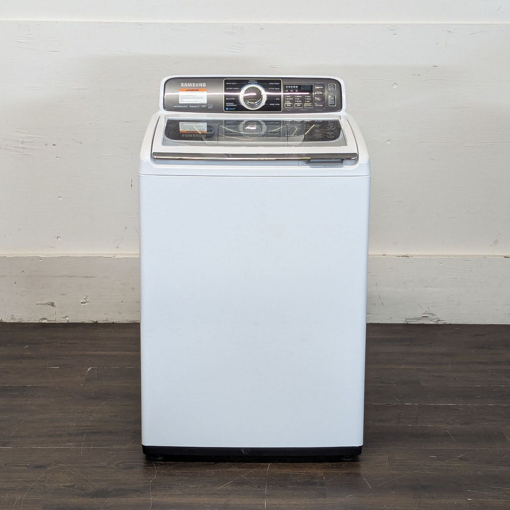 1. Samsung top-load washer or dryer with digital controls, shown with the lid closed, on a wooden floor.