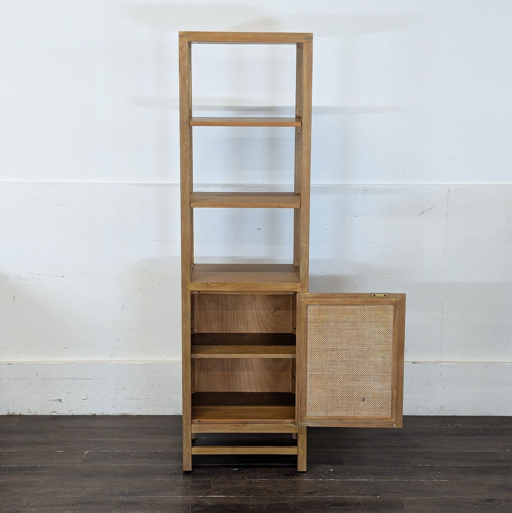 Open wooden cabinet by Crate & Barrel with two shelves, bottom storage, and cane door displayed ajar.  