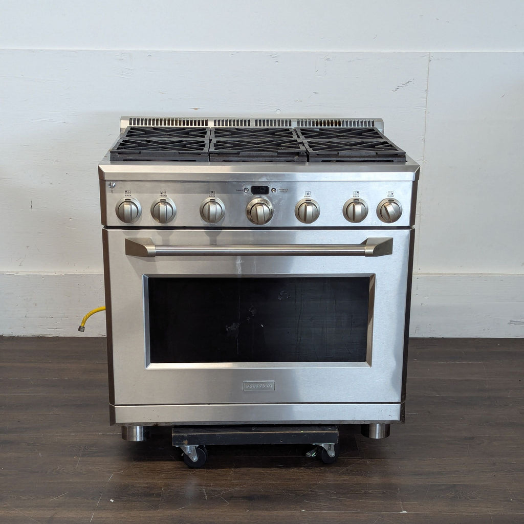 Monogram stainless steel stove & oven with matching control knobs and a sturdy oven handle.  