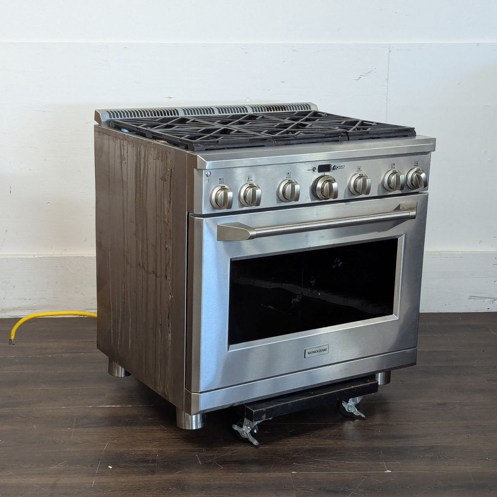 Stainless steel Monogram stove & oven, sealed burners, control knobs, and strong oven handle shown.