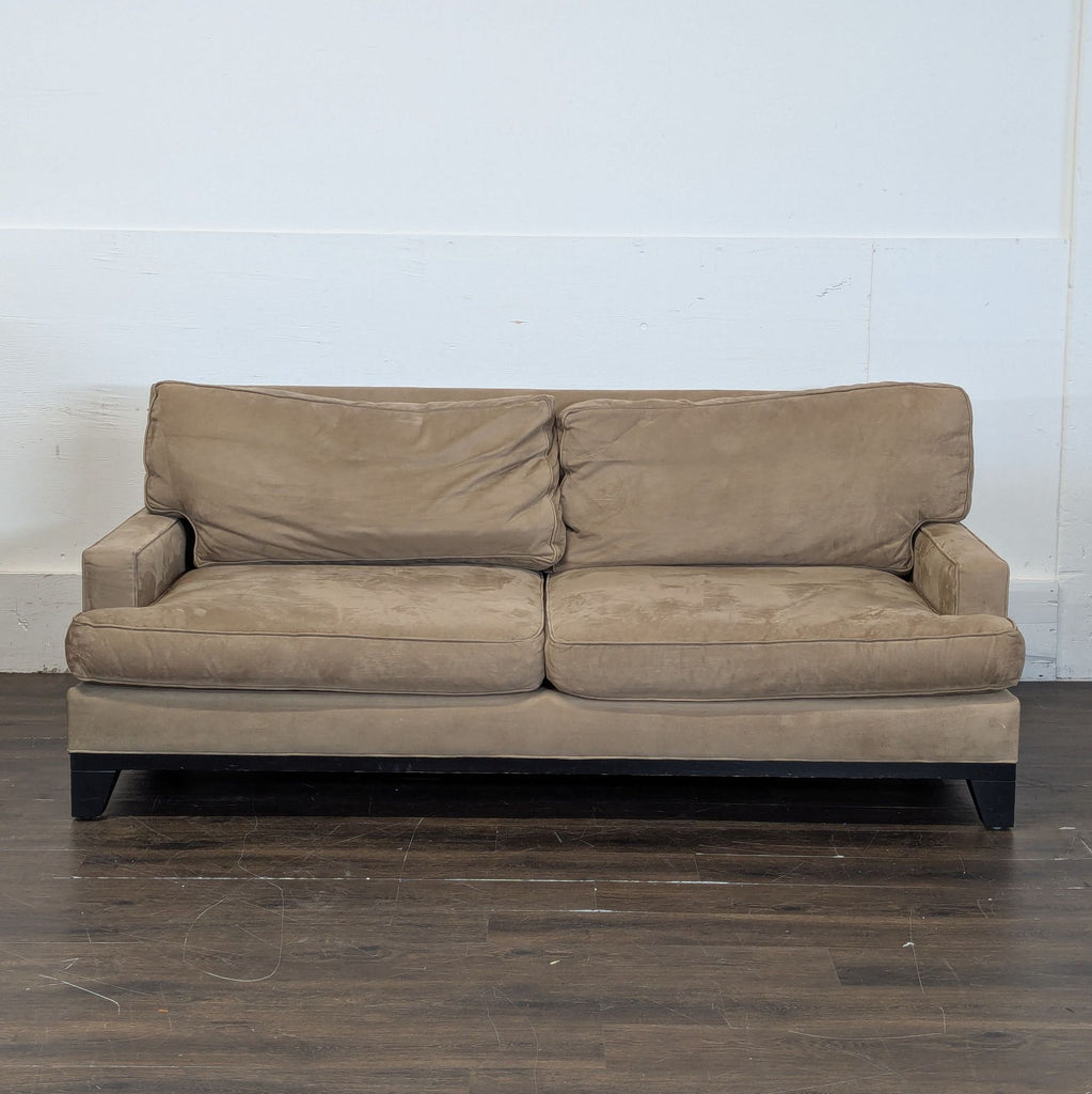 1. Modern blue loveseat with plush cushions and wooden legs in a bright living room.
