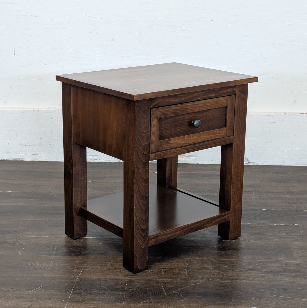 2. Sleek black metal end table with a glass top, styled next to a sofa in a living room.