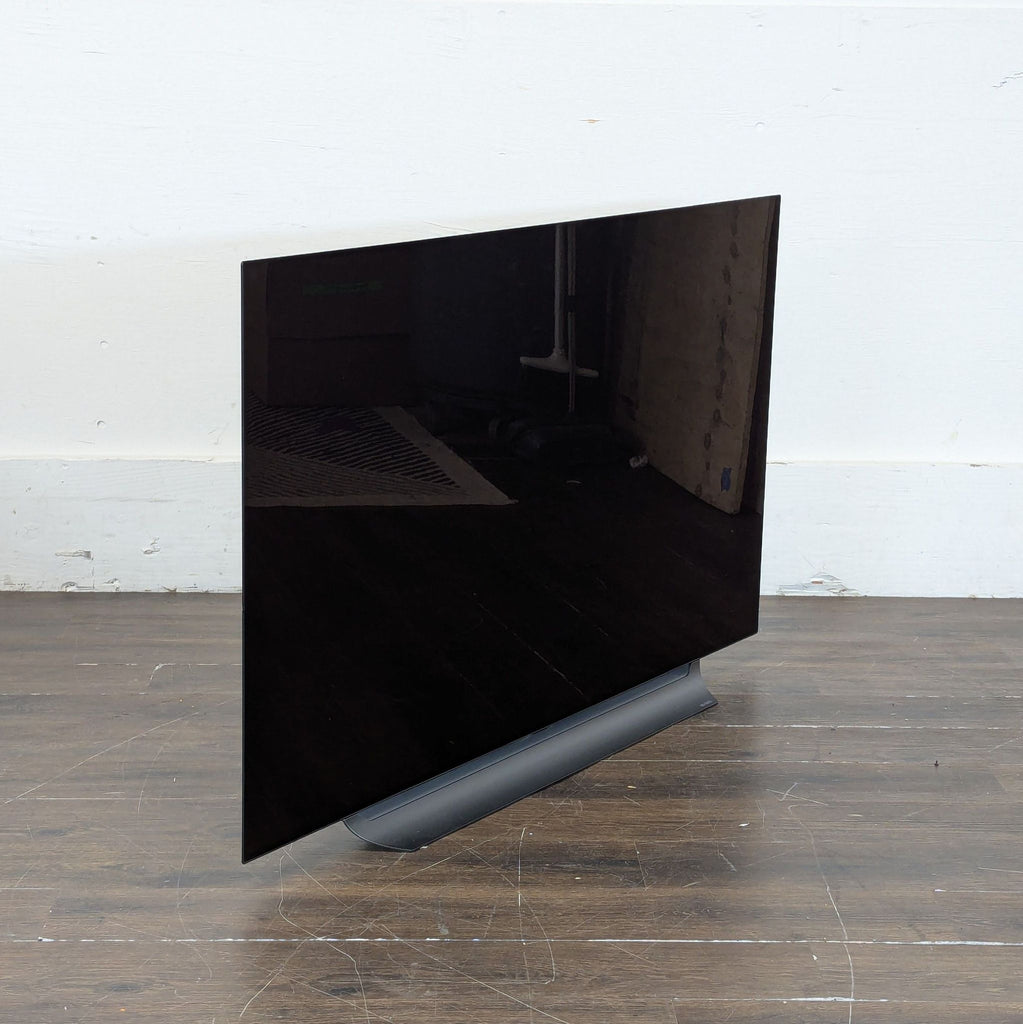 2. Ultra-thin television mounted on a living room wall, showing a bright landscape scene.