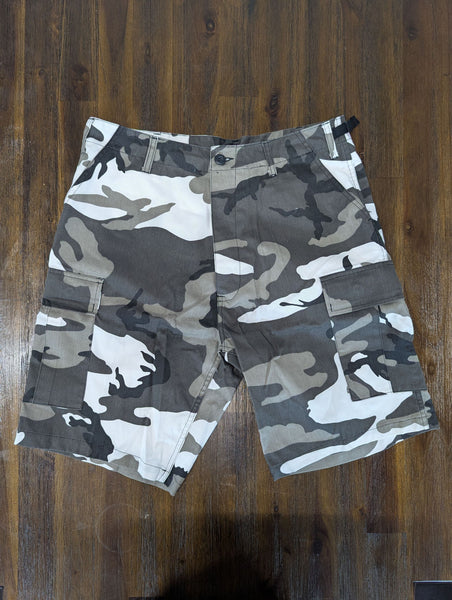 1. Front view of men's cargo shorts in gray and white camouflage pattern, displayed on a wooden floor.