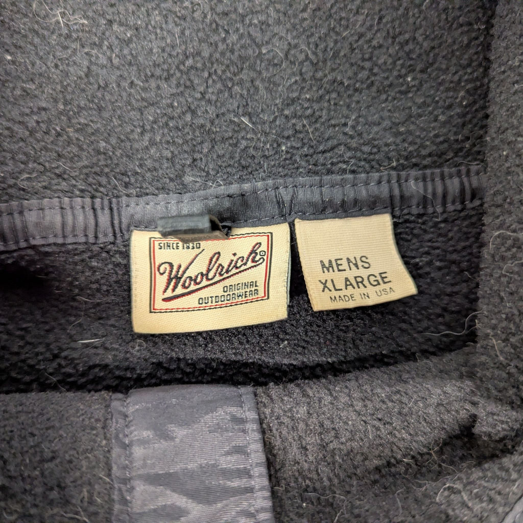3. Close-up of Woolrich brand and size tags reading "Mens XLarge" and "Made in USA" inside the fleece.