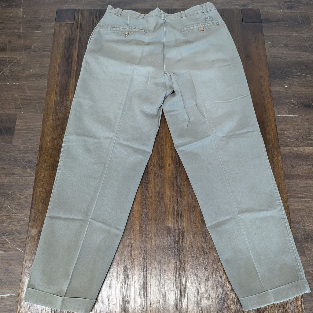 Khaki men's pants displayed on a wooden surface, showing back pockets and tailored fit.  