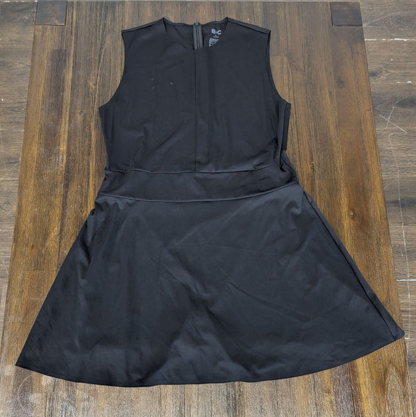 1. Sleeveless black Uniqlo women's dress laid flat on a wooden floor, showcasing the front design and A-line skirt.