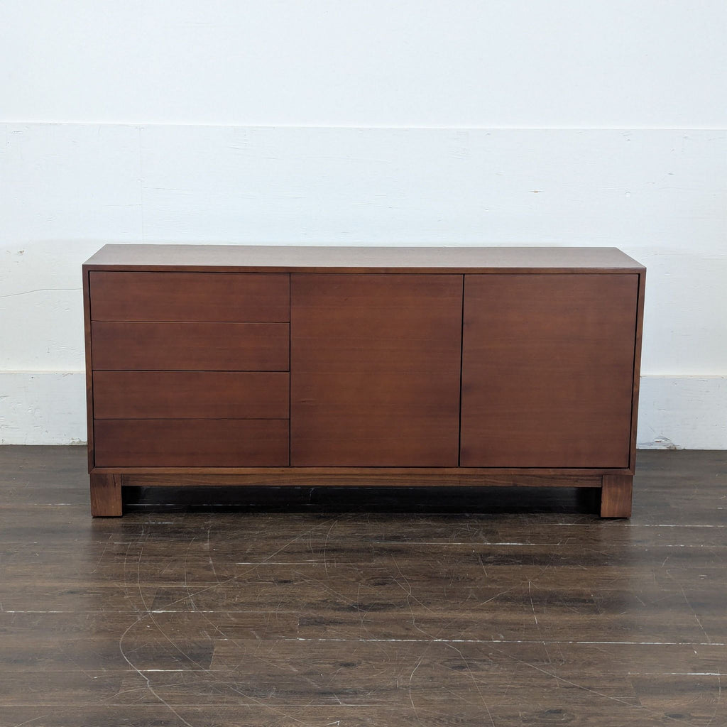 2. Sleek Mitchell Gold + Bob Williams credenza in dark wood finish with minimalist design, viewed against a plain wall.