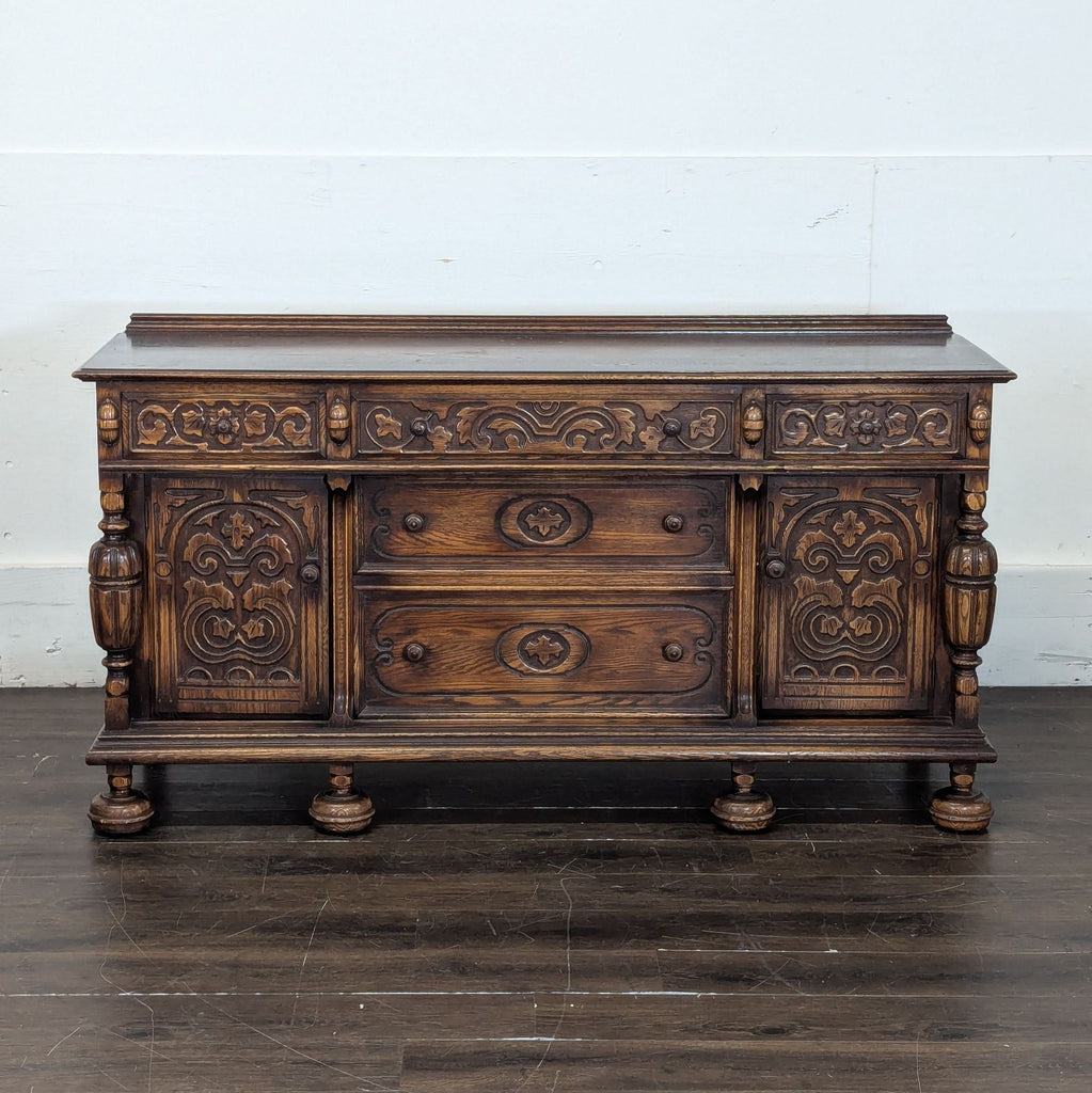 Antique dark wood credenza featuring detailed carvings, turned legs, and decorative moldings.