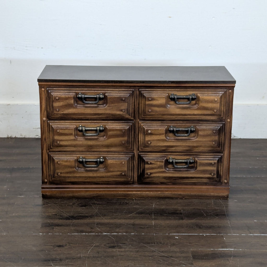 1. Front view of a six-drawer wooden dresser with decorative metal handles and a dark finish, category Dressers.
