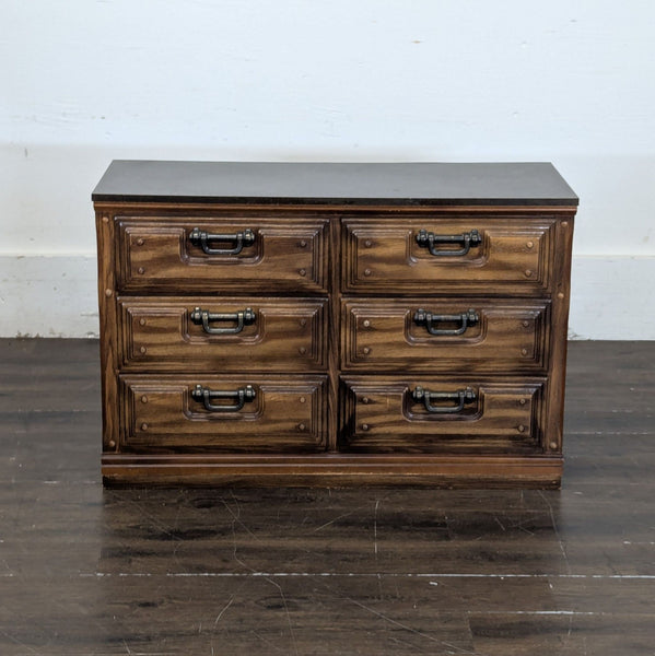1. Front view of a six-drawer wooden dresser with decorative metal handles and a dark finish, category Dressers.