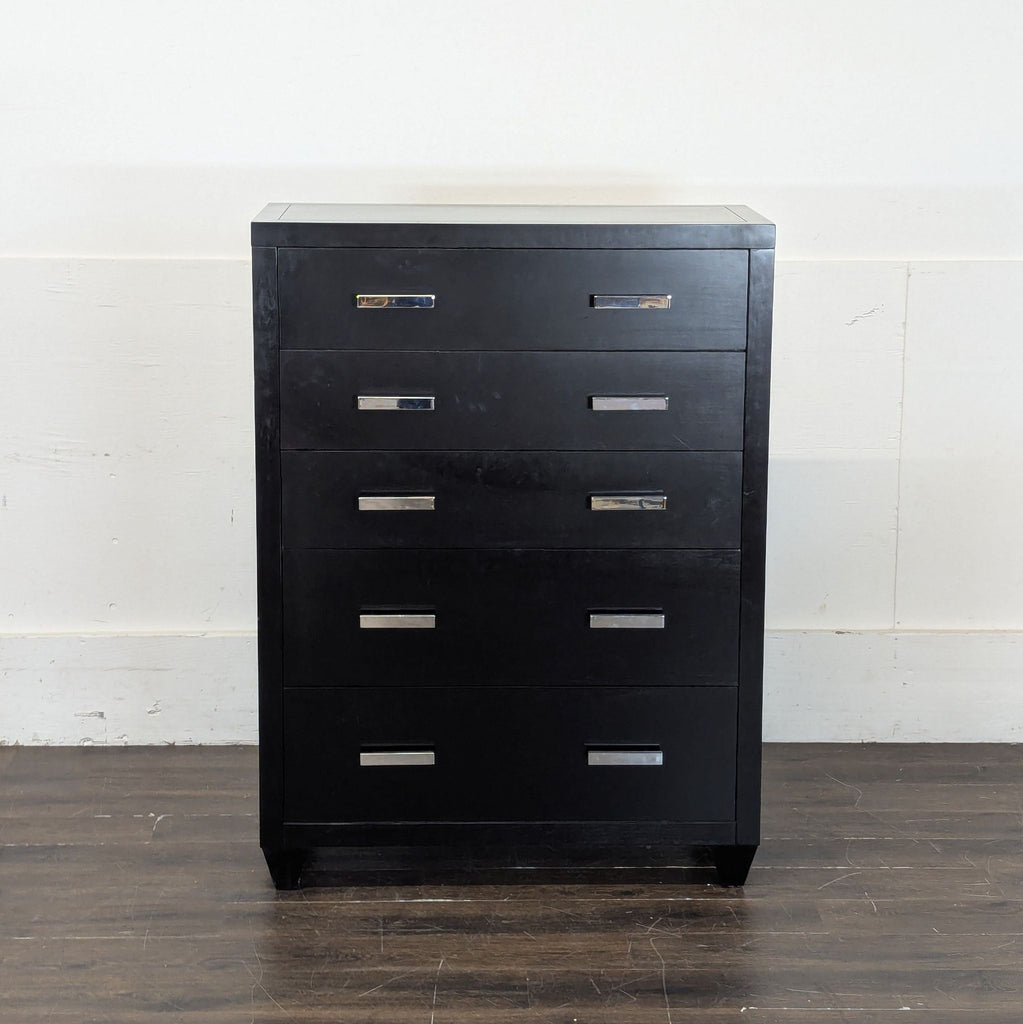 2. Modern black Pottery Barn dresser, five spacious drawers, silver hardware, shown against white wall.  