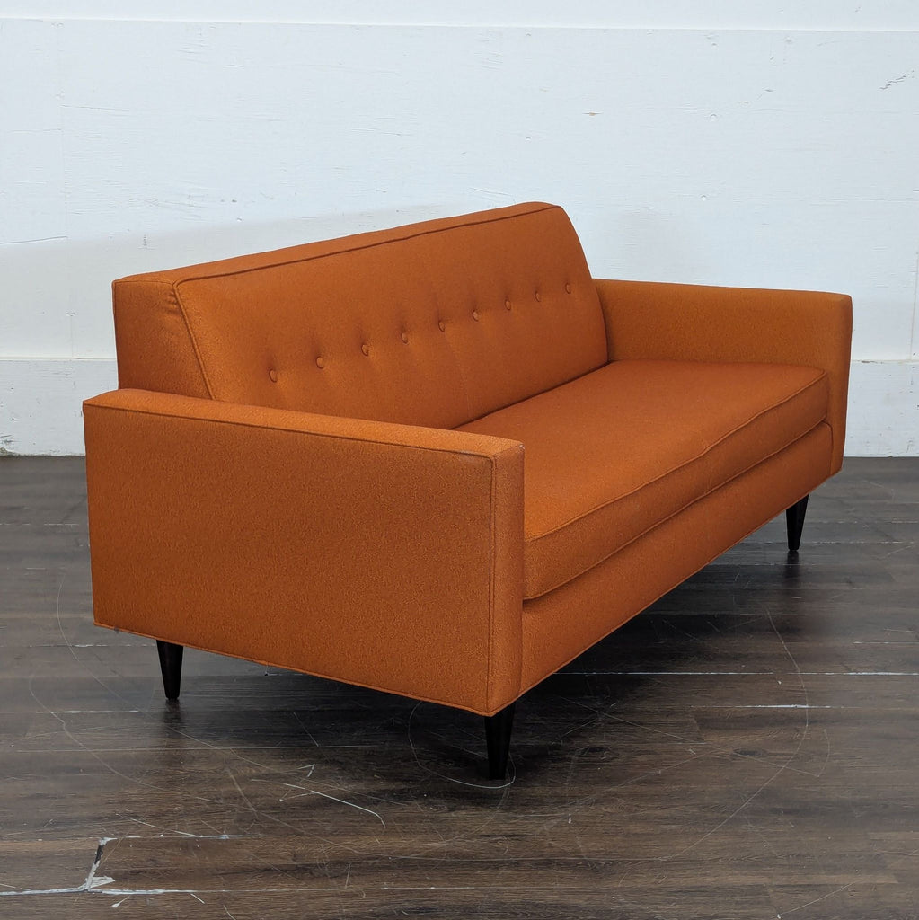 2. Stylish three-seater couch with wooden legs, designed for both comfort and elegance.