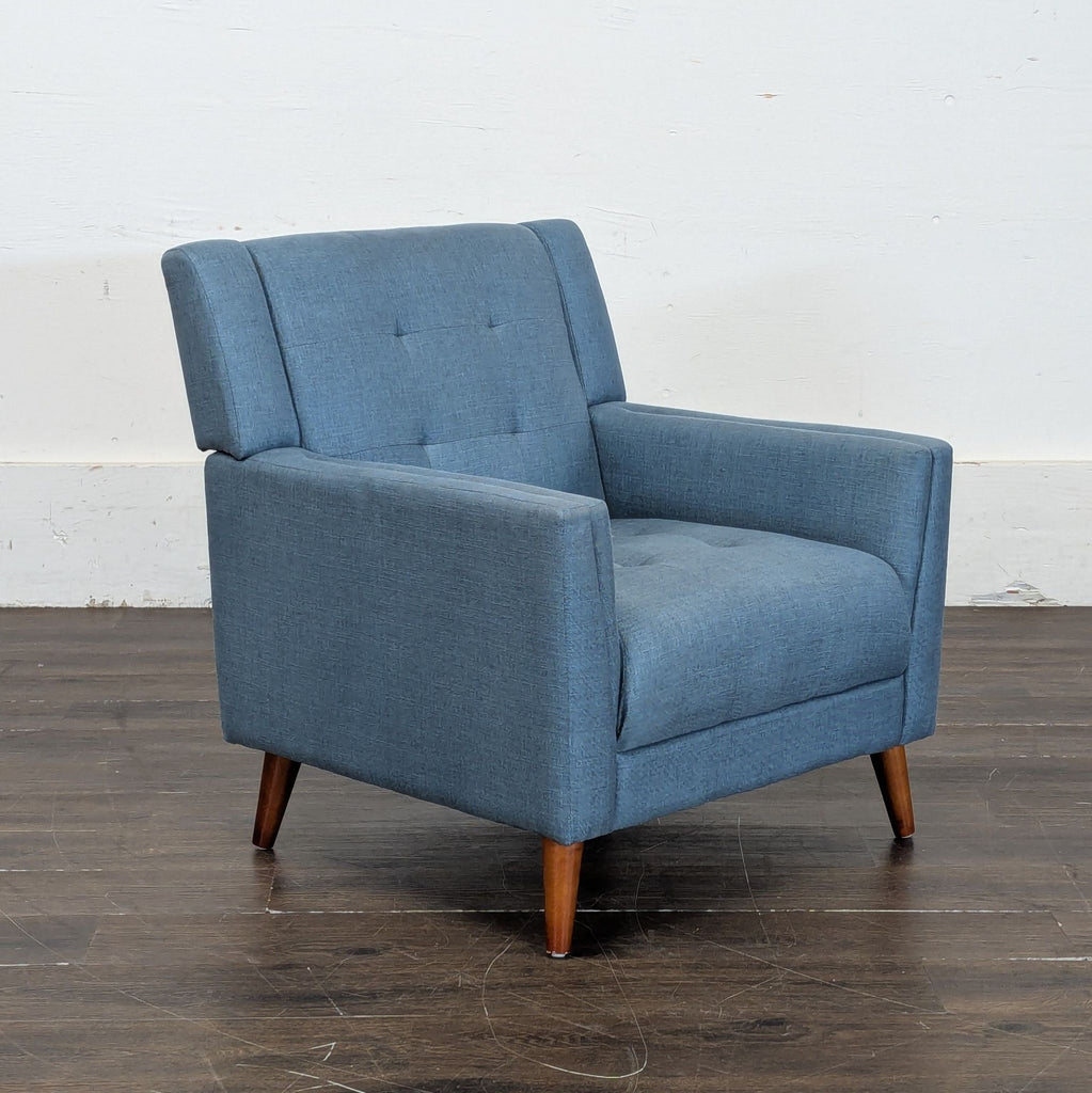 2. Mid-century style blue lounge armchair with angled wooden legs and tufted back, shown at an angle.